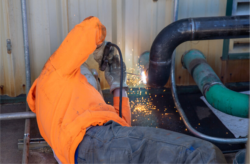 Regenis technician welding a piping system together