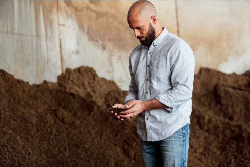 Regenis employee holding dirt